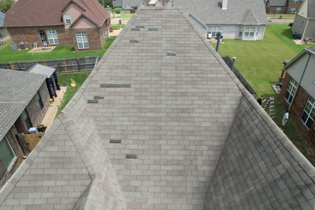 Missing shingles due to wind damage on a roof after a recent storm. The recent storm damage in Memphis, TN has caused many roofs to lose their shingles.