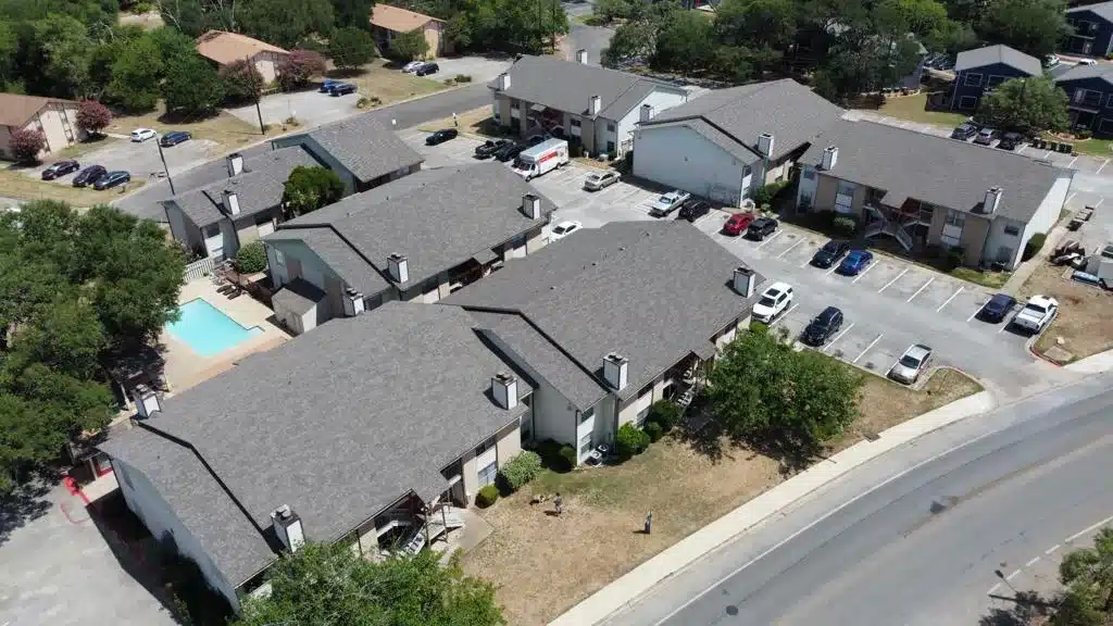 Aerial view of apartment buildings with parking area.